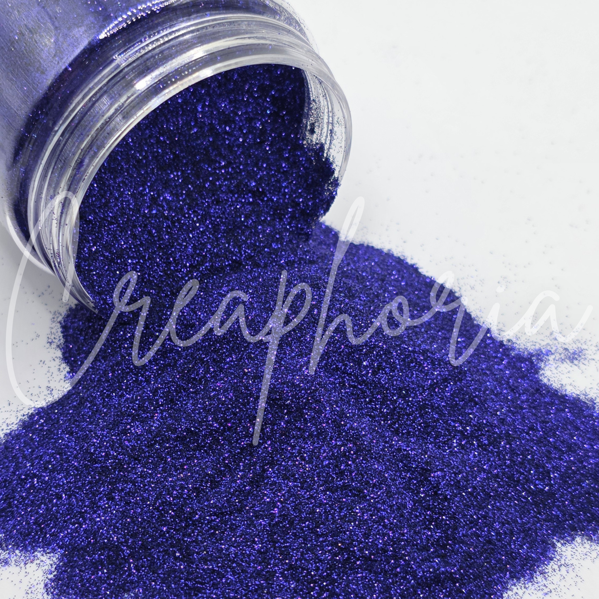 Blue glitter spilling out of a clear container on a white background